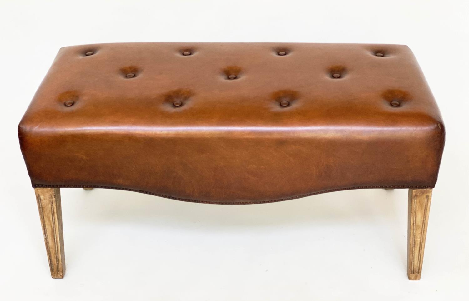 HALL BENCH, brass studded tan leather upholstered with bowed under tier, 100cm W x 45cm D x 50cm H.