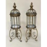 STORM LANTERNS ON STAND, a pair, metal and glazed with handles and scroll supports, 106cm H. (2)