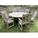 CIRCULAR GARDEN TABLE AND CHAIRS, silvery weathered teak, a set of six armchairs by Lister and a