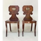 HALL CHAIRS, a pair, George IV mahogany with scroll carved and incised backs and painted monograms