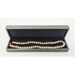 A CULTURED PEARL SINGLE STRAND NECKLACE, 8mm pearls, yellow metal and garnet set clasp, 42cm long,