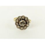 A DIAMOND CLUSTER SET YELLOW METAL RING, the central stone of approximately 0.60ct, surround by