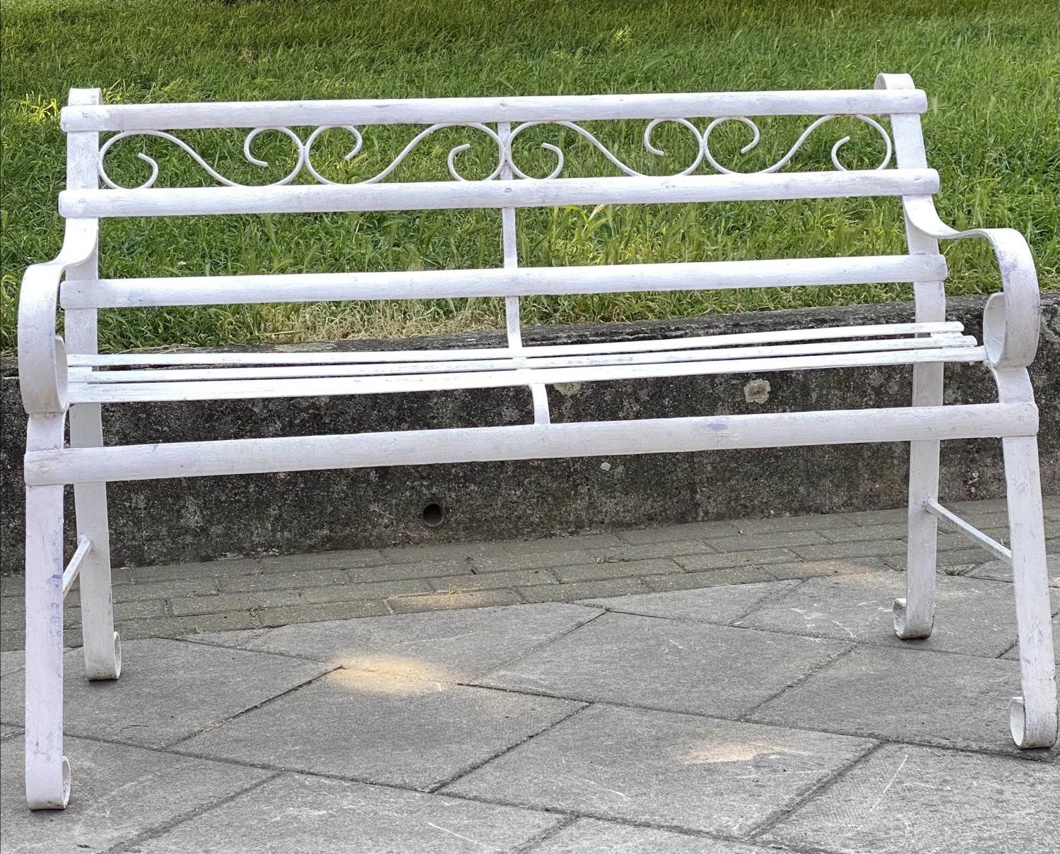 GARDEN BENCH, antique wrought iron and white painted with slatted back and seat and scroll arms,