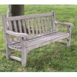 LISTER GARDEN BENCH, well weathered teak of Country House proportions, slatted with scroll arms, R A