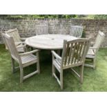 CIRCULAR GARDEN TABLE AND CHAIRS, silvery weathered teak, including a set of six armchairs by Lister