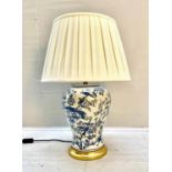 TABLE LAMP, 55cm high, 35cm diameter, blue and white glazed ceramic, gilt base, with a pleated