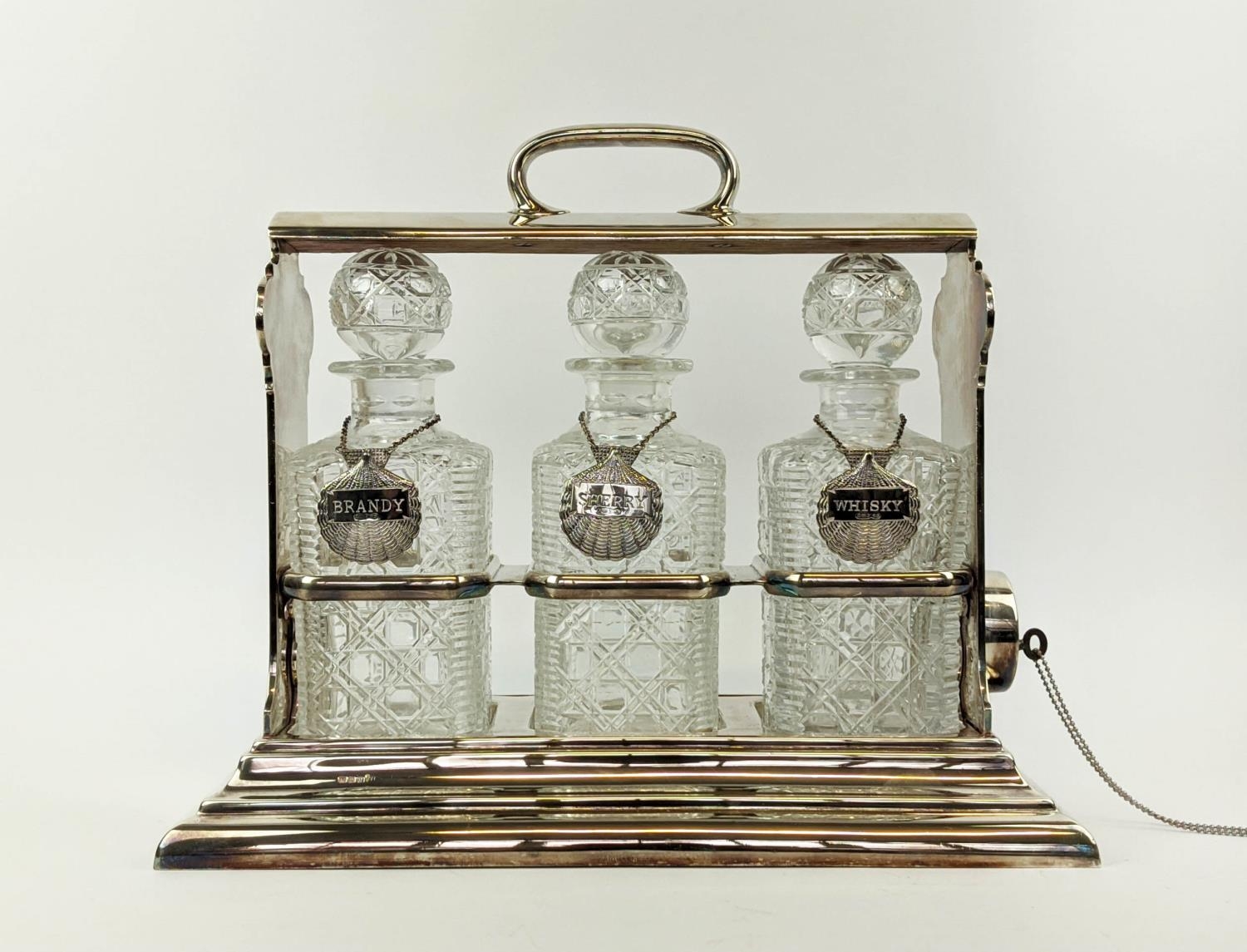 A WALKER AND HALL SILVER PLATED TANTALUS fitted with three square cut glass decanters, carrying