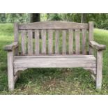 GARDEN BENCH, weathered teak of slatted and pegged construction with flat top arms and arched