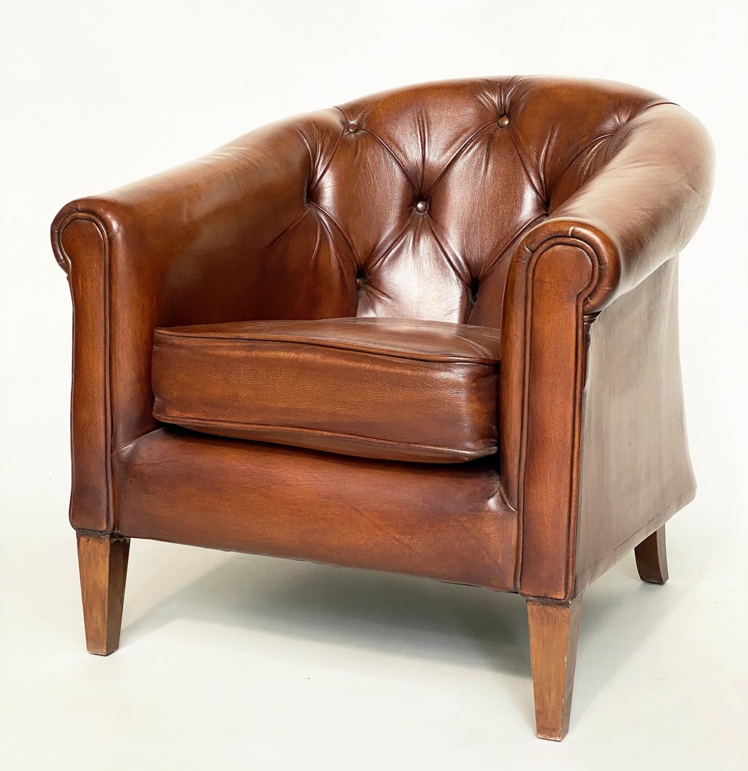 TUB ARMCHAIR BY THOMAS LLOYD, buttoned tan leather with arched back and rounded arms, 78cm W.