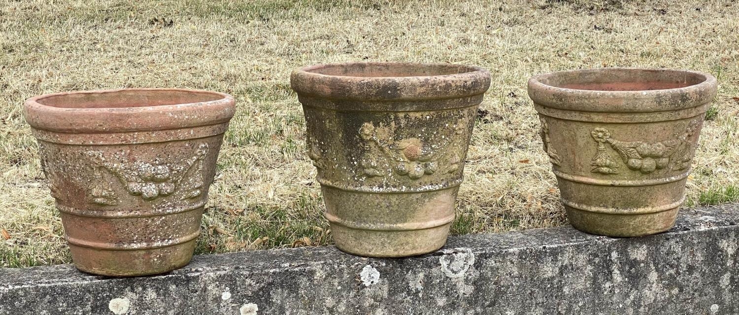 GARDEN TERRACOTTA PLANTERS, a set of three, large weathered terracotta with fruit decoration, 57cm W