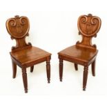 HALL CHAIRS, a pair, 19th century oak each with scroll and escutcheon carved backs and reeded