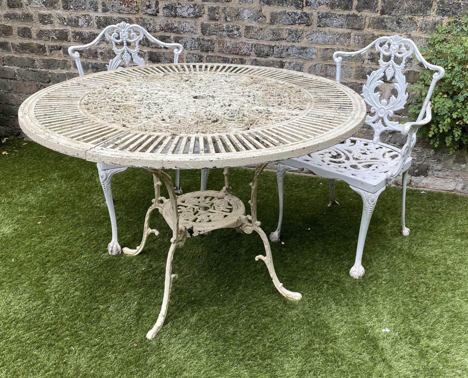 GARDEN TABLE AND CHAIRS, weathered painted cast aluminium circular pierced with two matching chairs,