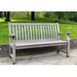 GARDEN BENCH, weathered teak of slatted construction with shaped back and scroll arms, 152cm W.