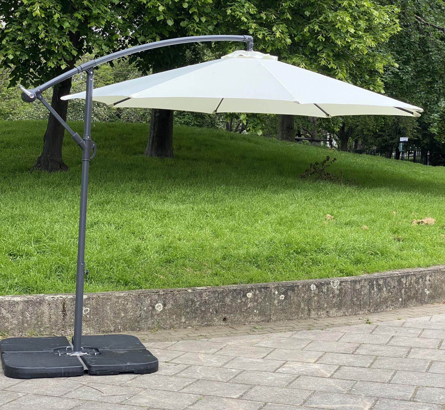 GARDEN PARASOL, circular cream canvas retractable wind up with frame and weights (water filled),