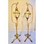 STORM LANTERNS ON STANDS, a pair, 163cm high, 35cm wide, Regency style, gilt metal. (2)