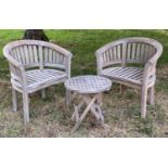 GARDEN CURVED ARMCHAIRS, a pair, weathered teak each slatted with rounded backs, together with an