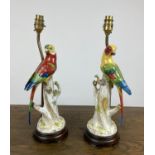 PARROT LAMPS, a pair, porcelain modelled perched on three stumps in bright painted coloured, 41cm H.