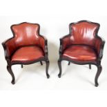 BERGERE TUB ARMCHAIRS, a pair, in burgundy leather having shaped carved sinuous mahogany showframe