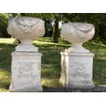 GARDEN URNS, a pair, well weathered reconstituted stone with swag detail and similarly decorated