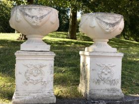 GARDEN URNS, a pair, well weathered reconstituted stone with swag detail and similarly decorated