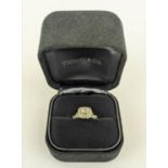 AN 18CT GOLD DIAMOND SET DRESS RING, the central princess cut diamond of approximately 0.25