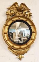 CONVEX MIRROR, 19th century giltwood, carved eagles crest above a convex plate with an ebony