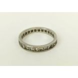 A DIAMOND SET ETERNITY RING, white metal shank set with round cut channel set diamonds, ring size '
