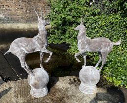 SCULPTURAL STAGS, a pair, 100cm high, 60cm wide, cast metal, on globular bases. (2)