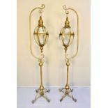 STORM LANTERNS ON STANDS, a pair, 163cm high, 35cm wide, Regency style, gilt metal. (2)