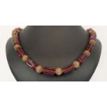 BEAD NECKLACE, believed to be Shakira Caine for Harrods, single strand with ruby coloured oblong