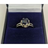 A SAPPHIRE AND DIAMOND SET DRESS RING, the single stone sapphire of approximately 1 carat, claw