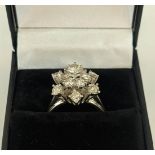 AN 18CT WHITE GOLD DIAMOND FLOWER HEAD COCKTAIL RING, with a central stone of approximately 0.25