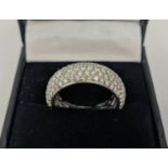 AN 18CT WHITE GOLD DIAMOND ENCRUSTED BAND, set with over 200 round cut pavé set diamonds, lattice