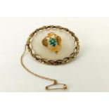 A LATE VICTORIAN YELLOW METAL AND CLEAR CHALCEDONY SET BROOCH, of oval form, probably 15ct gold,