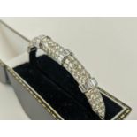 AN 18CT WHITE GOLD DIAMOND ENCRUSTED BANGLE, set with ninety round brilliant cut diamonds in four