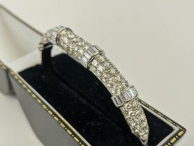 AN 18CT WHITE GOLD DIAMOND ENCRUSTED BANGLE, set with ninety round brilliant cut diamonds in four