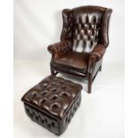 WING ARMCHAIR, deep buttoned brown leather, with brass stud work and stretchered legs with