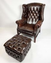 WING ARMCHAIR, deep buttoned brown leather, with brass stud work and stretchered legs with