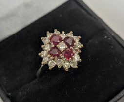 AN 18CT WHITE GOLD RUBY AND DIAMOND DRESS RING, set with four rubies and a central diamond,