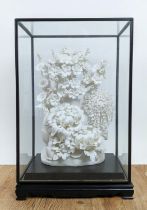 BLANC DE CHINE PORCELAIN FLOWER DISPLAY, with an ebonised and glass case, 54cm H x 34cm x 24cm.