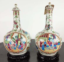 BOTTLE VASES, a pair, Chinese famille rose, with carved hardwood bases and covers, 41cm H. (2)