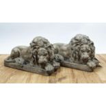 SCULPTURAL RECUMBENT LIONS, a pair, 52cm x 22cm x 30cm, resin, faux stone finish. (2)