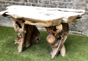GARDEN 'ROOT' TABLE, well weathered tree section with raw edge and knarled root base, 136cm W x 66cm