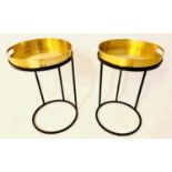 TRAY TABLES, 57cm high, 36cm in diameter, a pair, the gilt metal trays raised on black painted metal