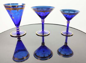 A SET OF VENETIAN COBALT BLUE AND GOLD HAND PAINTED GLASSES, seven champagne coupes, nine martini