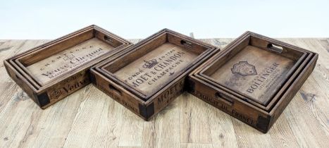DRINKS TRAYS, three graduated sets of three, stamped with various champagne houses, 56cm x 38cm x
