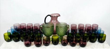 OKA GLASS WATER JUGS AND TUMBLERS, an amethyst jug and twenty four tumblers, two green jugs and