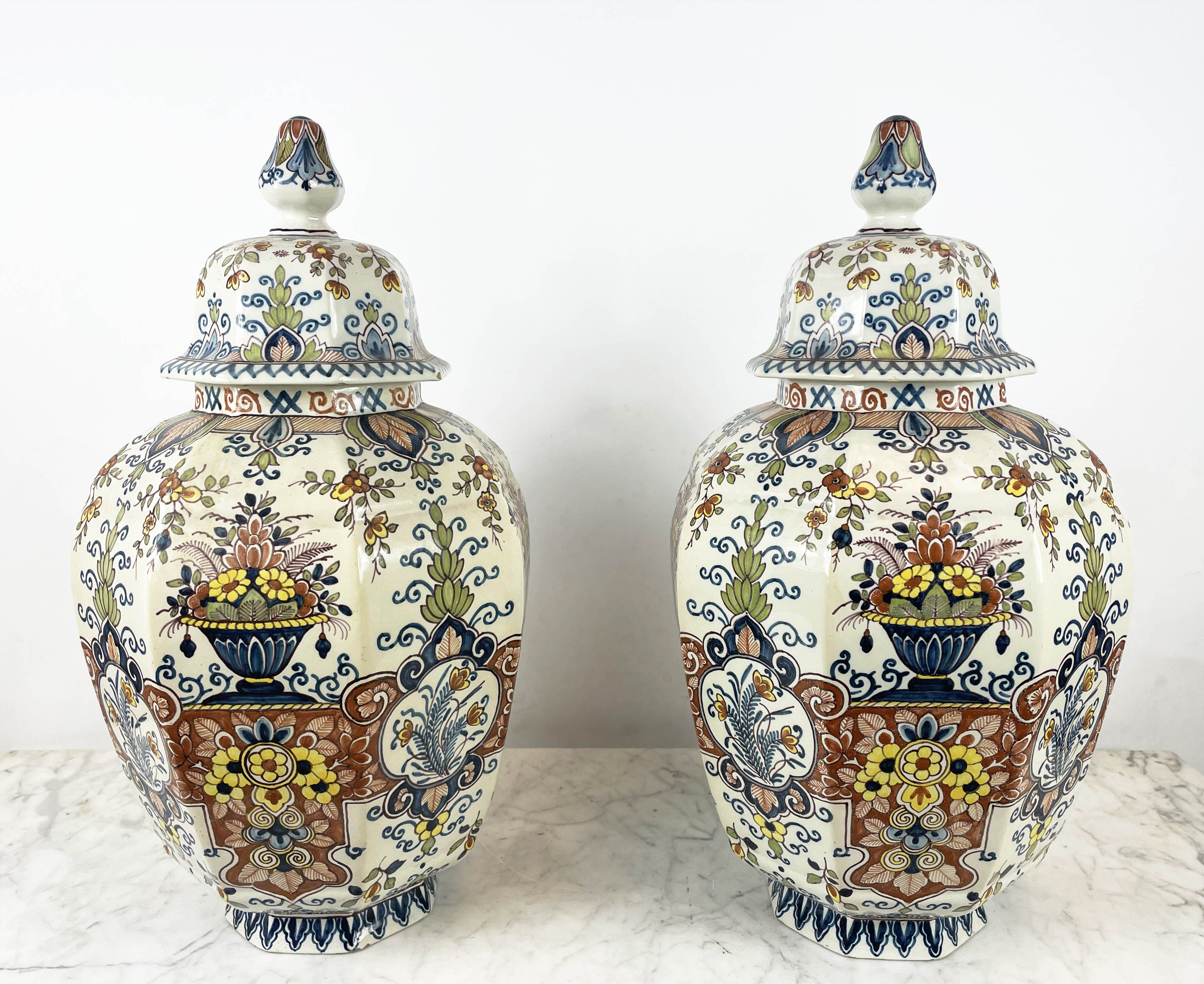 LIDDED DELFT VASES, a pair, 19th century polychrome painted, faceted octagonal form, with foliate