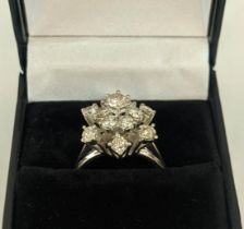 AN 18CT WHITE GOLD DIAMOND FLOWER HEAD COCKTAIL RING, with a central stone of approximately 0.25