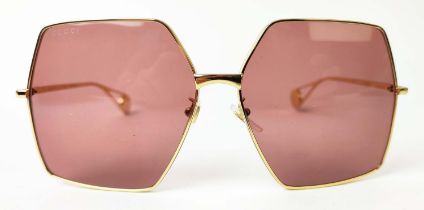 GUCCI SUNGLASSES, oversized hexagonal frame in gold tone hardware with logo at the edge of the